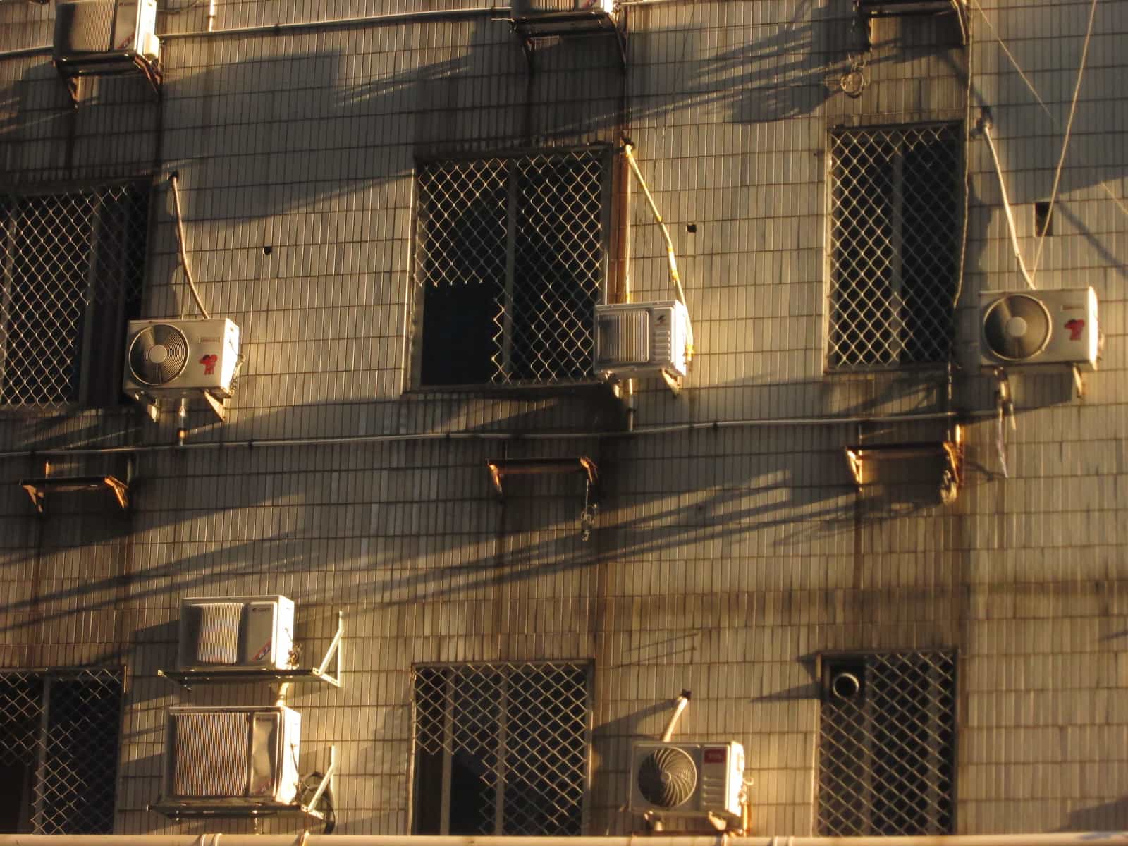An outdoor condenser unit standing in bright sunlight
