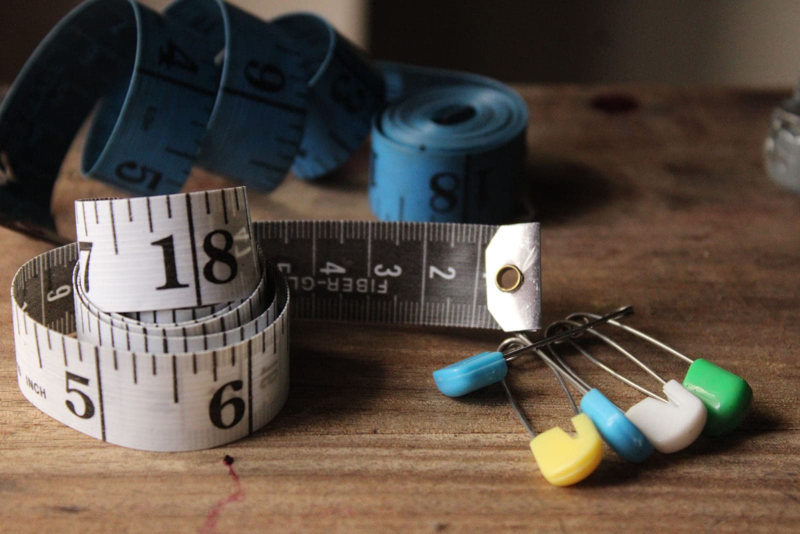 A measuring tape and hand tools on a bench
