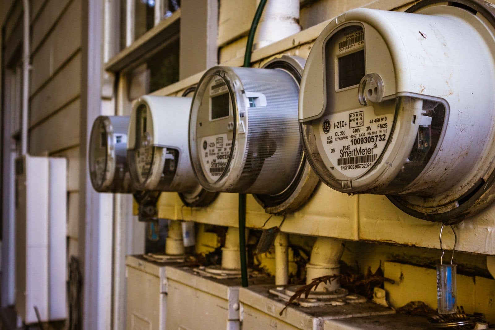A row of residential electricity meters on an exterior wall