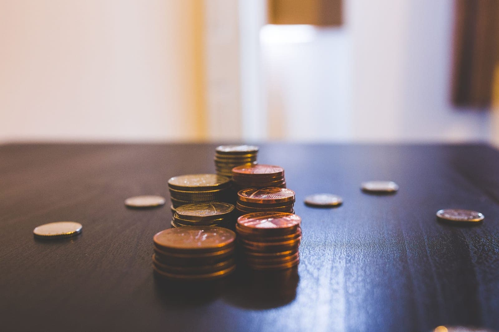 Stacked coins on a plain wooden surface