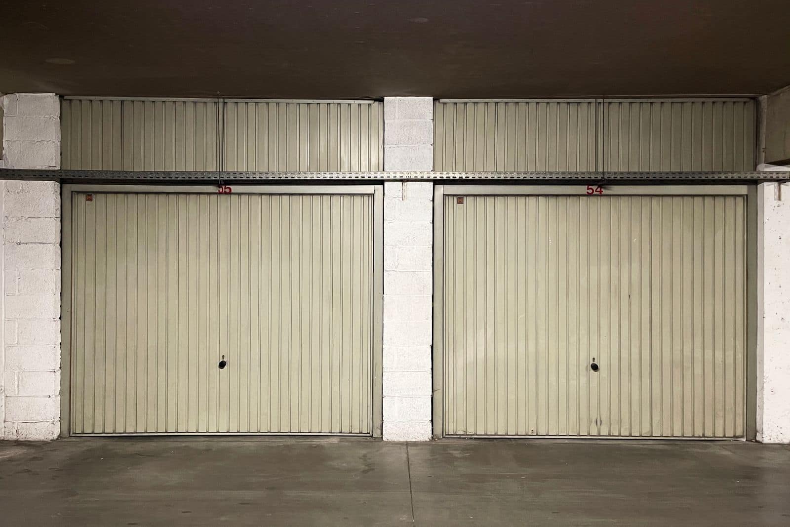 Closed garage doors in an empty concrete space