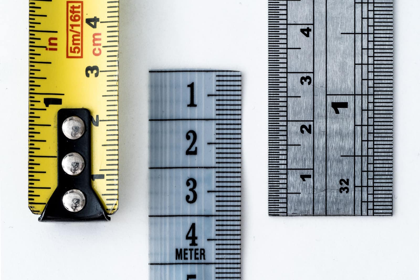 A tape measure and rulers showing inch and centimeter markings